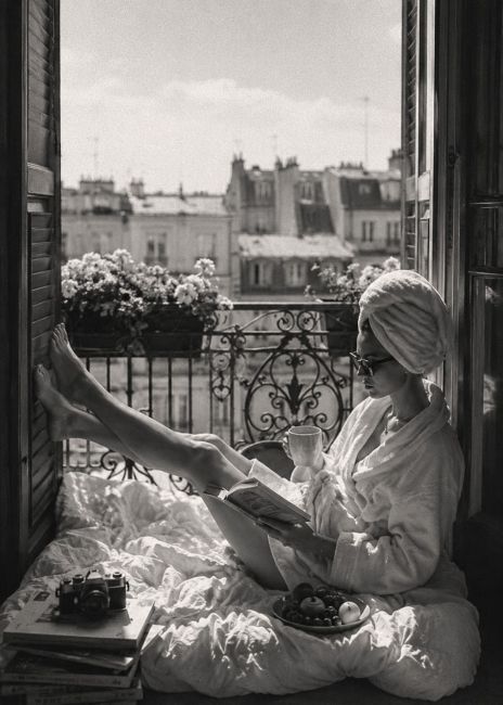 Zwart-wit wanddecoratie van een ontspannen ochtend op een Parijs balkon met koffie, boek en uitzicht over de karakteristieke daken van de stad.