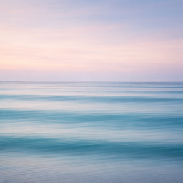 Minimalistische zee bij zonsondergang met pastel roze lucht en zachte blauwe golven als moderne wanddecoratie.
