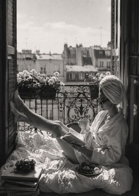 Zwart-wit wanddecoratie van een ontspannen ochtend op een Parijs balkon met koffie, boek en uitzicht over de karakteristieke daken van de stad.