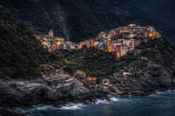Mediterraans kustdorp bij avond met verlichte huizen en zee romantische coastal village wanddecoratie