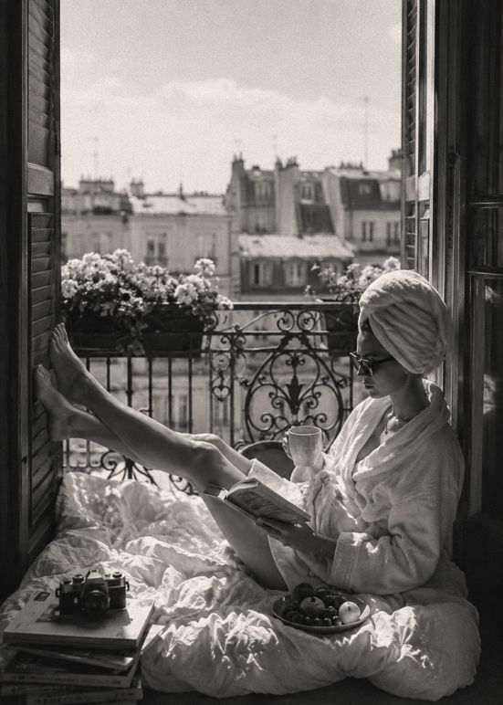 Zwart-wit wanddecoratie van een ontspannen ochtend op een Parijs balkon met koffie, boek en uitzicht over de karakteristieke daken van de stad.