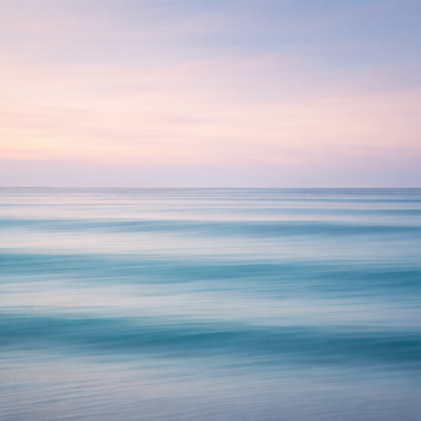 Minimalistische zee bij zonsondergang met pastel roze lucht en zachte blauwe golven als moderne wanddecoratie.