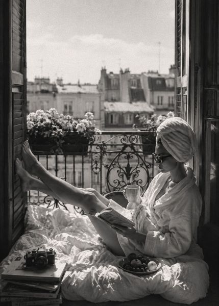 Zwart-wit wanddecoratie van een ontspannen ochtend op een Parijs balkon met koffie, boek en uitzicht over de karakteristieke daken van de stad.